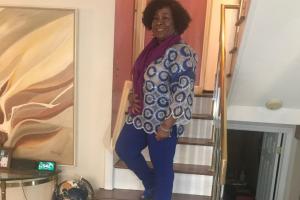 Barbara standing confidently on staircase after healing from bullous pemphigoid with care from Summit Health